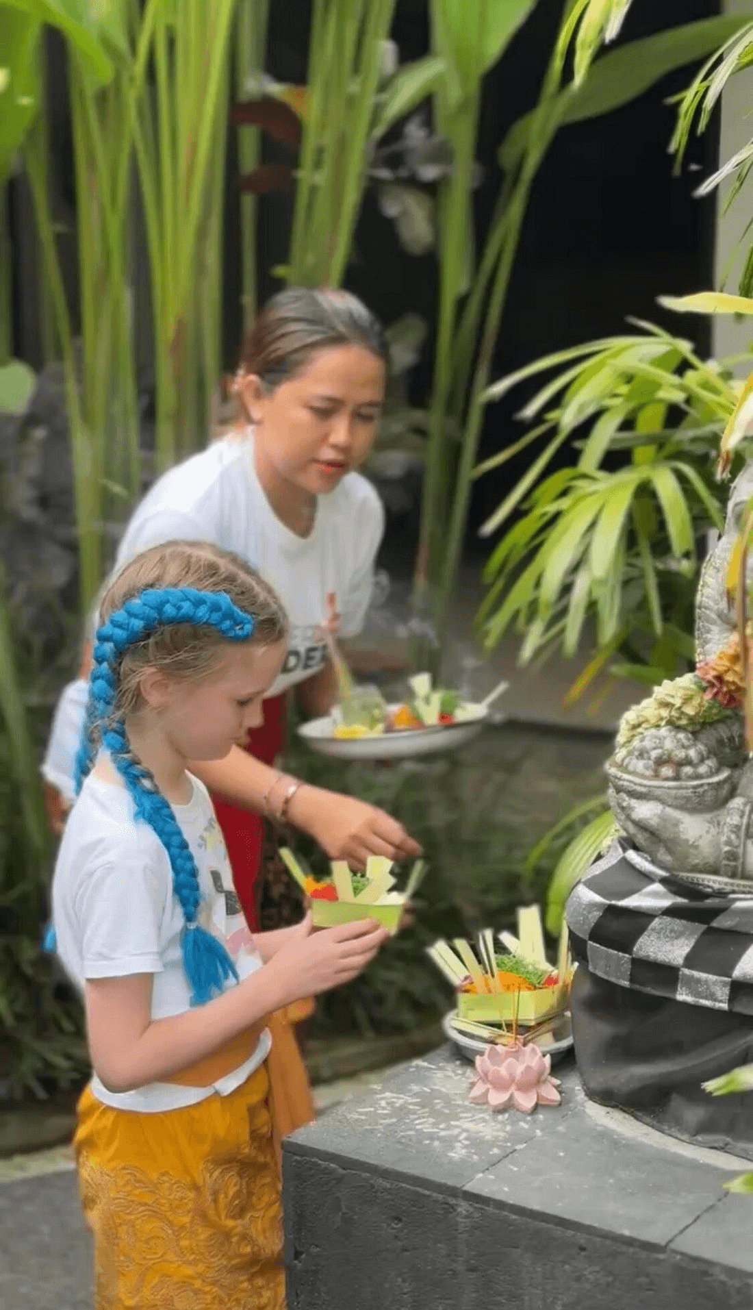 A child and host making a Balinese offering
