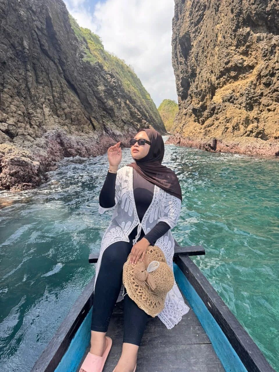Guest in a small boat between tall rock walls at Bedil Island