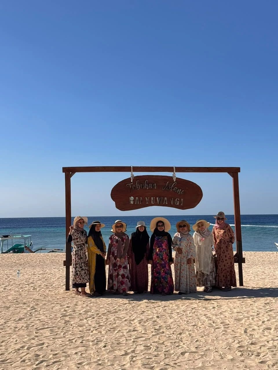 Guests posing under the Tabuhan Island Banyuwangi sign