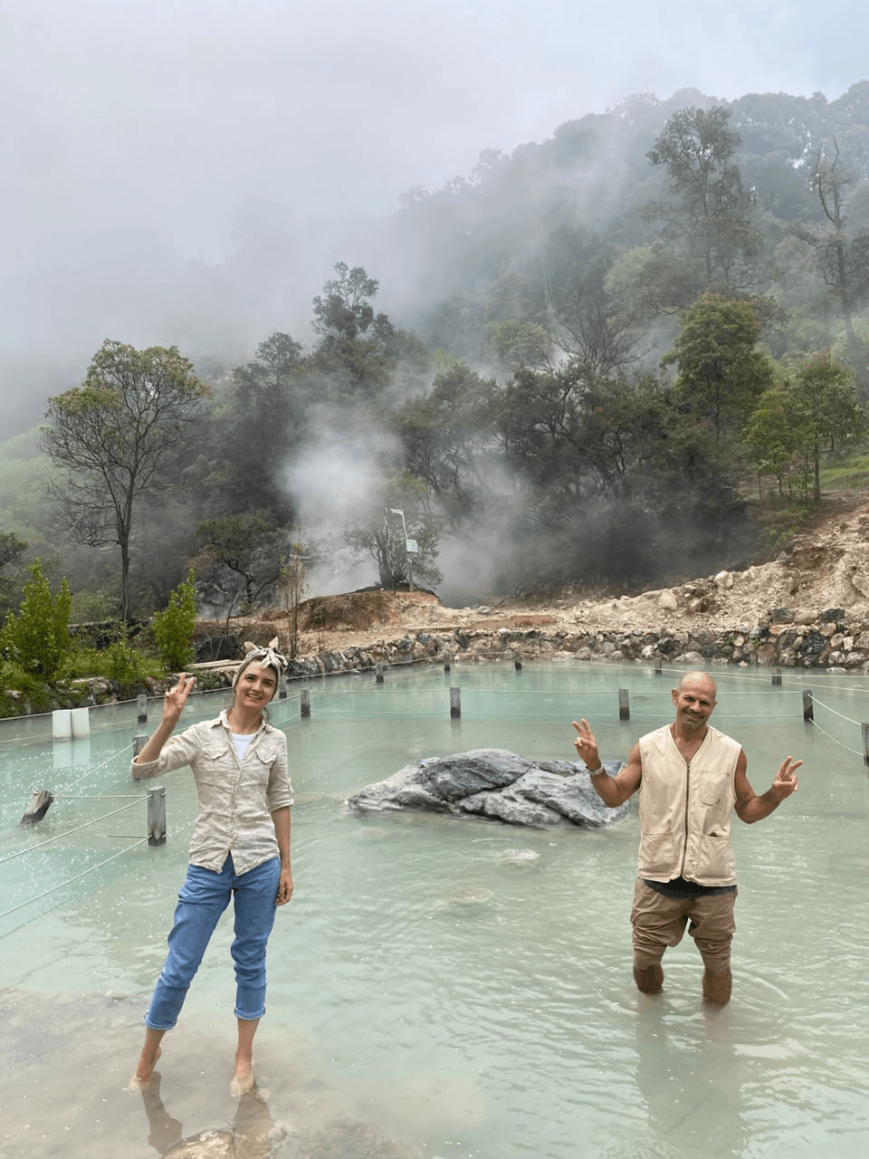 Guests in a warm turquoise pool with steam rising behind