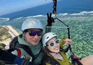 Two guests flying tandem over the reef