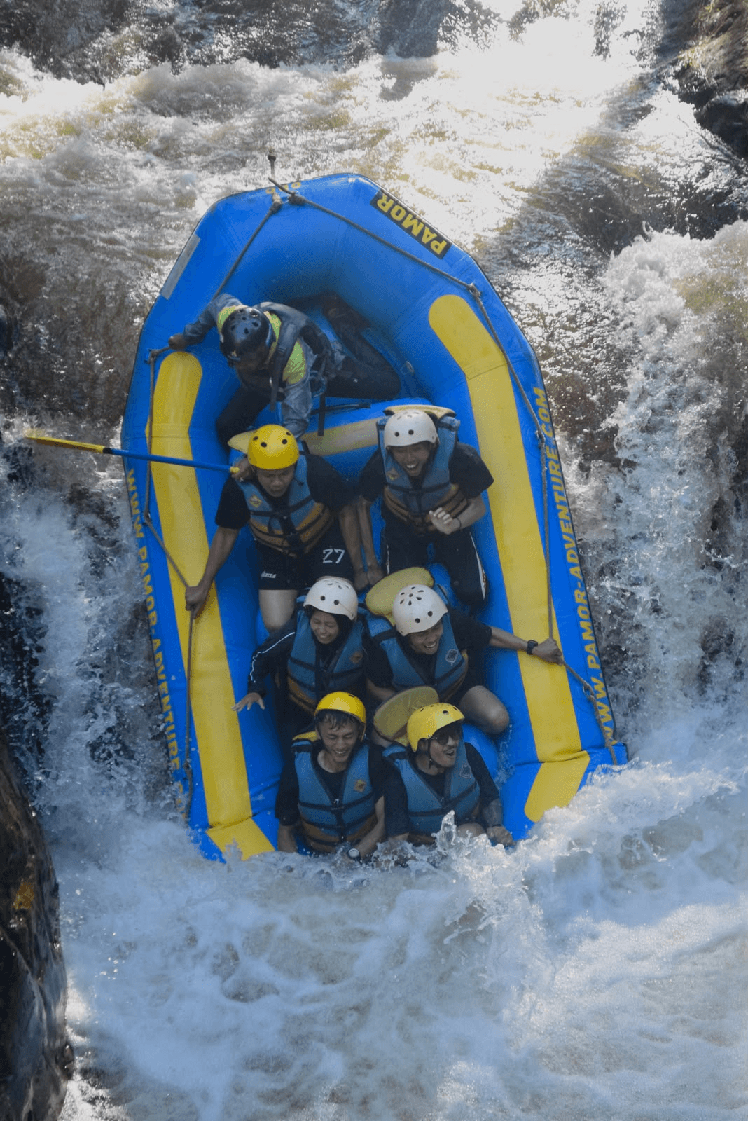 A raft full of guests dropping through a rapid in Pangalengan