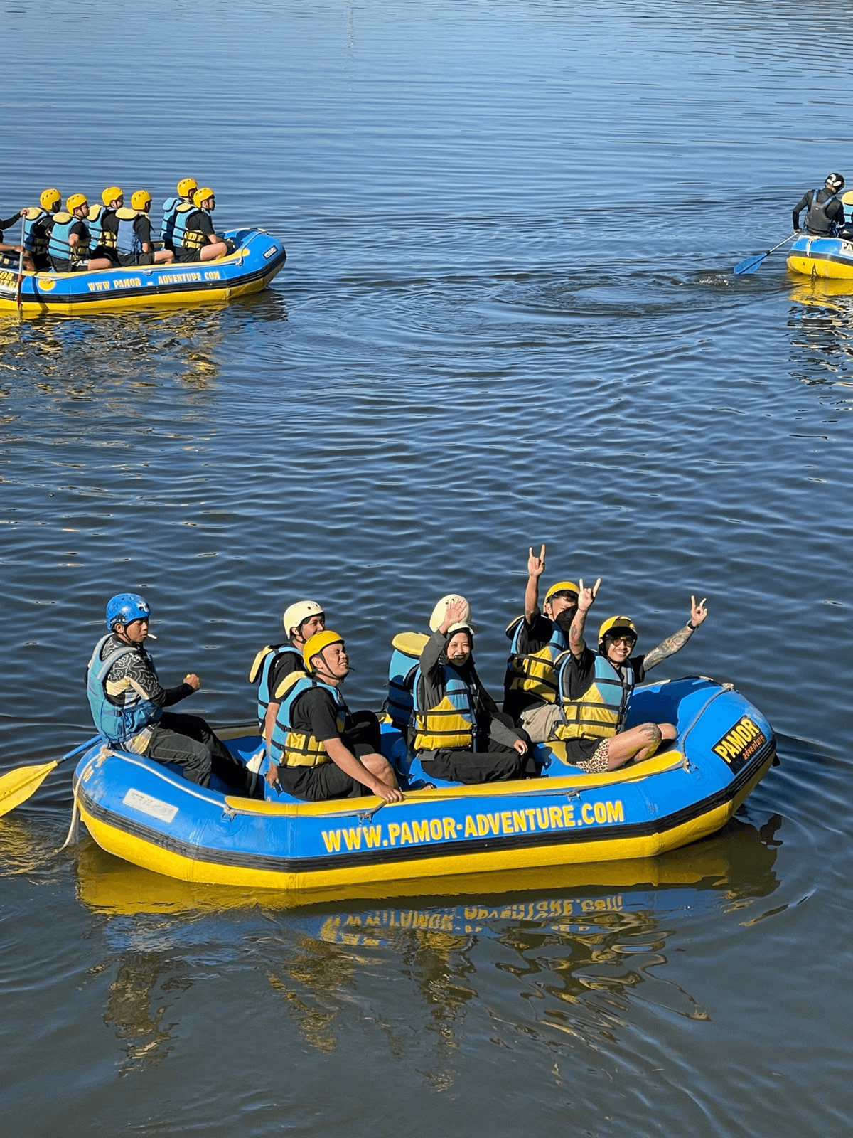 Guests waving from a raft on calm water